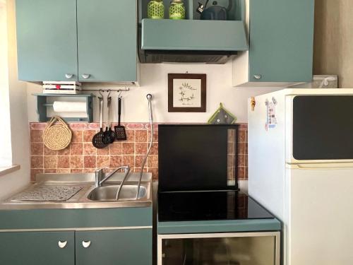a kitchen with blue cabinets and a sink and a refrigerator at Casa Lambertina in Senigallia