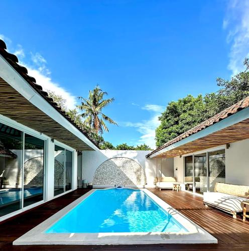 an infinity pool in the backyard of a house at Luxury at Family Ties Villa in Gili Air
