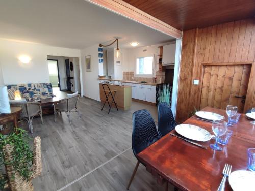 a dining room with tables and chairs and a kitchen at Vistamare sur Juno Beach - Vue Mer 4 pers in Courseulles-sur-Mer