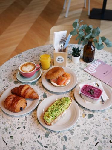 a table with plates of breakfast foods on it at Ariv Design Hotel Zug in Zug