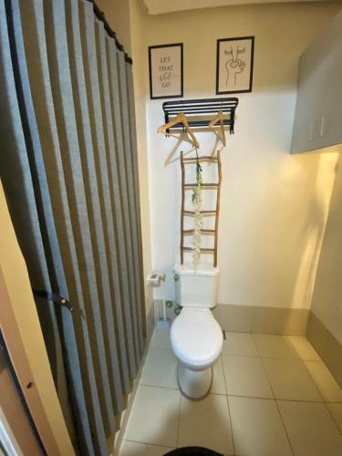 a bathroom with a toilet and a shower curtain at A&A cabin in Manila