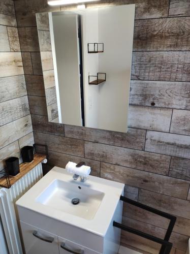 une salle de bain avec un lavabo et un miroir dans l'établissement Vistamare sur Juno Beach - Vue Mer 4 pers, à Courseulles-sur-Mer