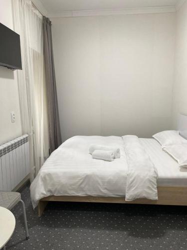 a bedroom with a bed with two towels on it at Turan in Karagandy