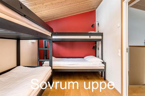 two bunk beds in a room with a red wall at Beach Villa Åre in Åre