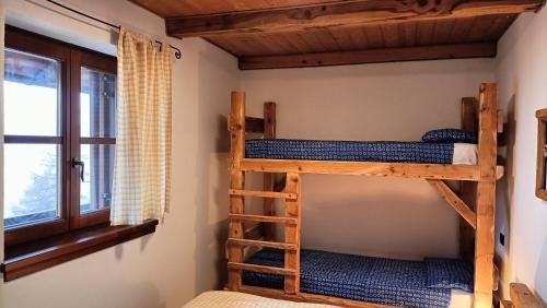 two bunk beds in a room with a window at Baita Compet in Vetriola