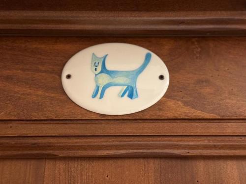 a plate with a blue cat on a wooden door at Chambres D'hôtes Maribel in Pré-Saint-Didier