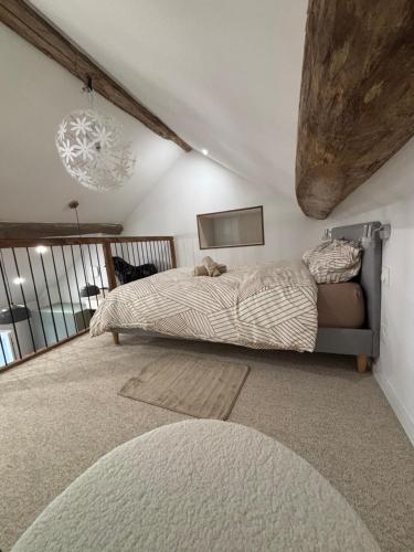 une chambre avec un lit et un lustre dans l'établissement Le refuge des Amoureux, à Briord