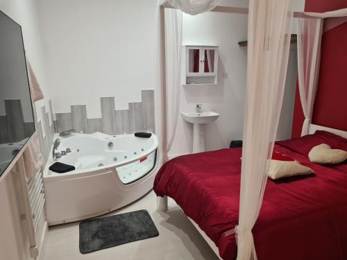 a bathroom with a tub and a bed and a sink at La Cachette des Murmures- Balnéo Privée I Détente in Boulogne-sur-Mer