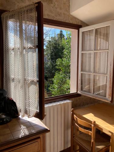 une cuisine avec une fenêtre et une table avec une chaise dans l'établissement la porte verte, à Montauban