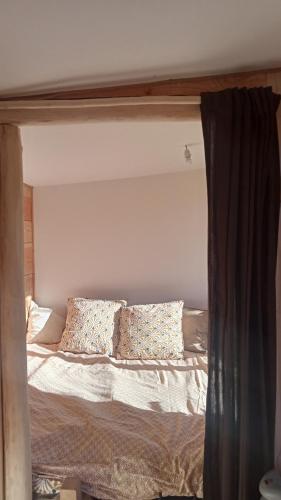un lit avec des oreillers dessus dans une chambre dans l'établissement Original tiny, à Aspet