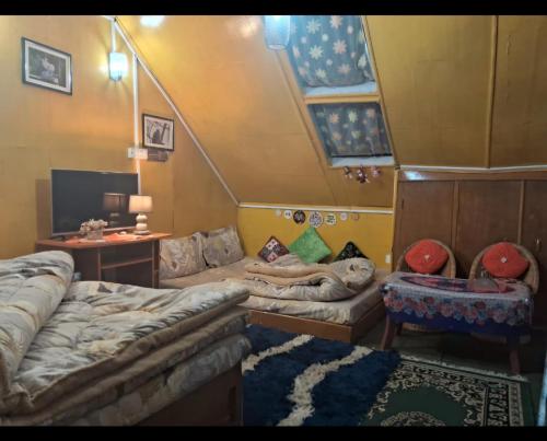 a room with two beds and a couch in it at Darjeeling Nest in Darjeeling