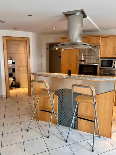 a kitchen with a counter and two stools in it at Petit Madlein in Ischgl
