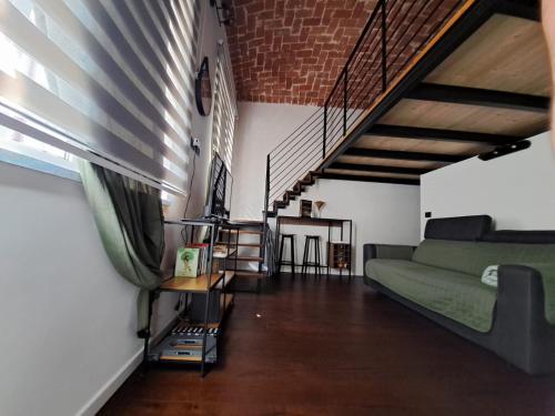 a living room with a green couch and a staircase at Frabosa Loft in Turin