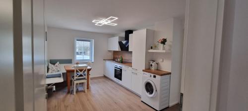 a kitchen with a washer and dryer and a table at gemütliche Ferienwohnung Achteltal in Simmelsdorf