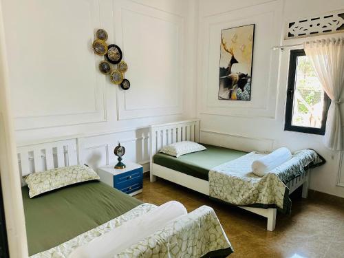 a bedroom with two beds and a window at Villa 3 , Phường2 Ngay trung tâm thành phố bảo lộc in Bao Loc