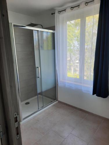 une douche avec une porte en verre à côté d'une fenêtre dans l'établissement Le Bâbord, à Honfleur