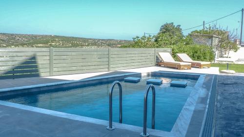 a swimming pool with two loungers at Olive Scent in Gouves