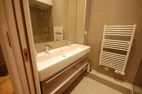 une salle de bain avec un lavabo blanc et un miroir dans l'établissement 2 chambres St Germain des Prés, à Paris