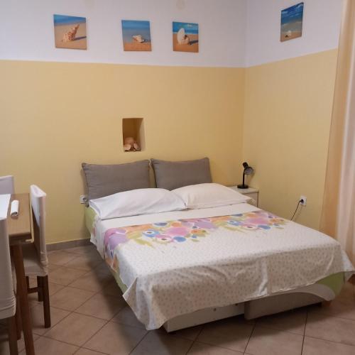 a bedroom with a bed and a desk at Apartmani Božić-Omišalj in Omišalj