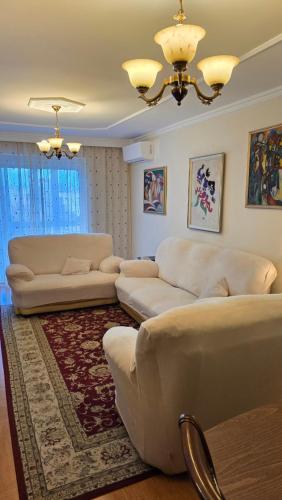 a living room with two white couches and a rug at City OASIS in the Heart of Tirana in Tirana