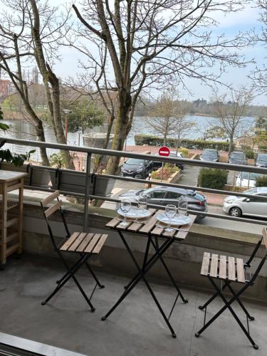 a table and chairs on a balcony with a view at Appartement vue sur Lac proche métro in Créteil