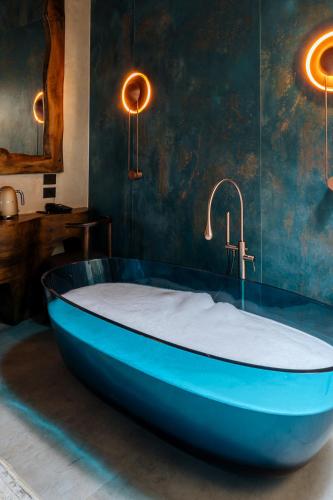 a blue bath tub in a room with a sink at Arctic Boutique Hotel in Korçë