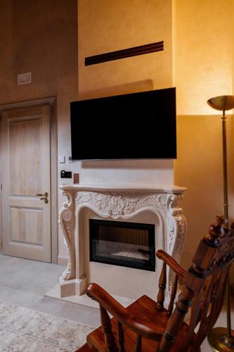 a living room with a fireplace with a flat screen tv at Arctic Boutique Hotel in Korçë