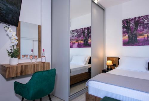 a bedroom with a bed and a green chair at Blue Balcony Boutique Beachfront Suite with Private Parking in Chania Town