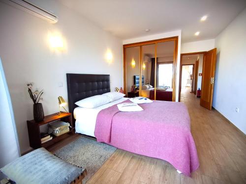 a bedroom with a large bed with a pink blanket at Porto River Sunset 1st in Vila Nova de Gaia