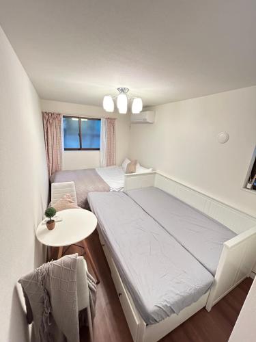 a small room with a bed and a table at Ueno new villa in Tokyo