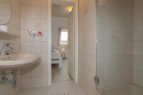 a bathroom with a sink and a shower at An der Düne 2, Whg 3 in Hörnum