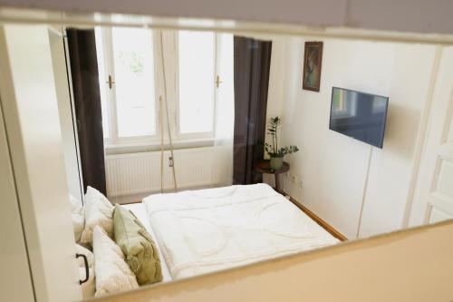 a reflection of a bed in a room with a window at Zentrales und stilvolles Apartment mit Schlossbergblick und Parkplatz in Graz
