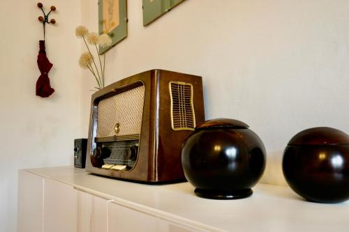 an old radio sitting on a shelf with two vases at Zentrales und stilvolles Apartment mit Schlossbergblick und Parkplatz in Graz