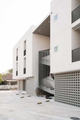 une vue extérieure d'un bâtiment avec un parking dans l'établissement Slee สลี, à Chiang Rai