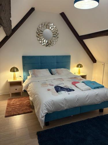une chambre avec un grand lit avec une tête de lit bleue dans l'établissement La Cigogne, à Strasbourg