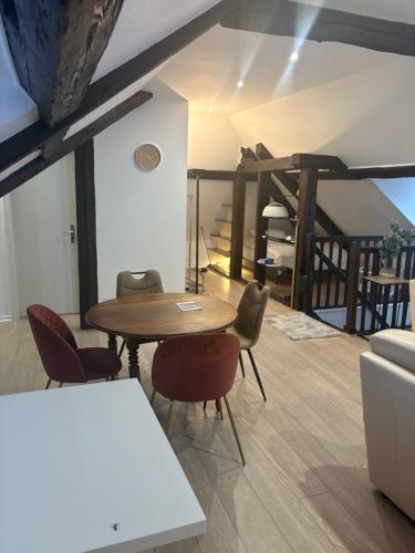 un salon avec une table et des chaises en bois dans l'établissement La Cigogne, à Strasbourg