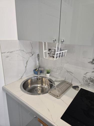 - un évier en argent dans une cuisine avec un comptoir dans l'établissement Studio dans maison familiale proche Paris et Disney, à Noisy-le-Grand