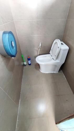 a bathroom with a toilet and a blue container at Natural Garden BMT in Buon Ma Thuot