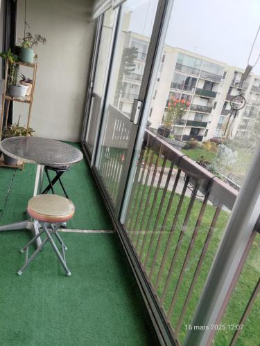 d'un balcon avec une table et une chaise devant une fenêtre. dans l'établissement Chambre à louer à saint-herblain, à Saint-Herblain