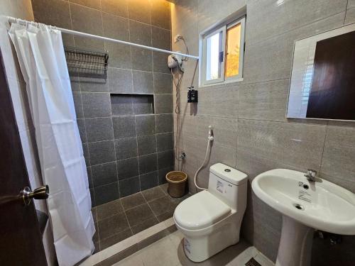 a bathroom with a toilet and a sink at Amado Transient Inn in Prado