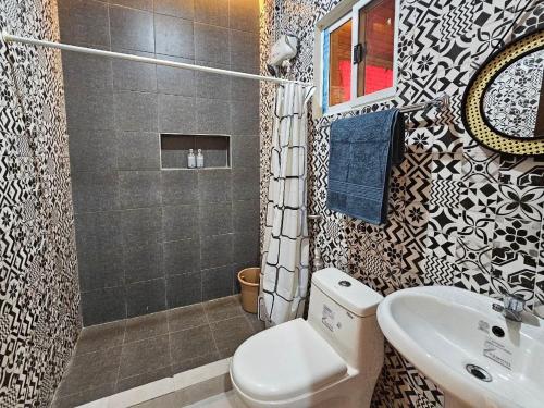 a bathroom with a toilet and a sink and a shower at Amado Transient Inn in Prado