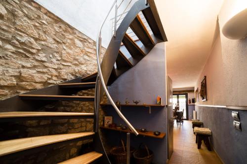 a staircase in a room with a stone wall at Rural Colldejou Cal Caterí in Colldejou