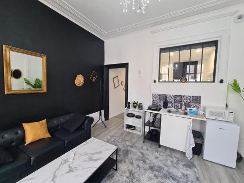 un salon avec un canapé et une cuisine dans l'établissement Suite Versailles I Luxe & Détente, à Boulogne-sur-Mer