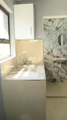 a kitchen with a sink and a counter top at Gift Guest house 3 in Cravenby