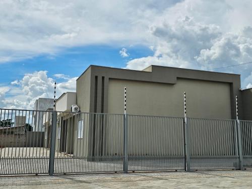 a building with a fence in front of it at Louvre Residence 202, conforto, estacionamento e wi-fi in Sinop