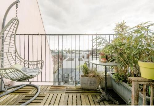 a balcony with a swinging chair and a table with plants at Suite place de l'Etoile in Strasbourg