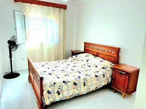 a bedroom with a bed and a table and a window at Sunny Stay, Plage & Attractions à 5 Min in Mostaganem