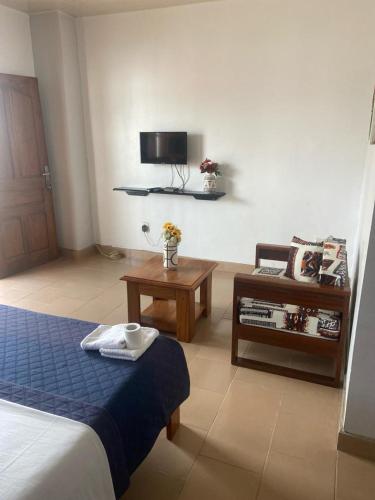 a hotel room with a bed and a table with a table at Hotel Madou Grand Bassam in Grand-Bassam