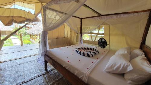 a bedroom with a bed with a canopy at Kirepwe Ecco Camp Watamu in Watamu