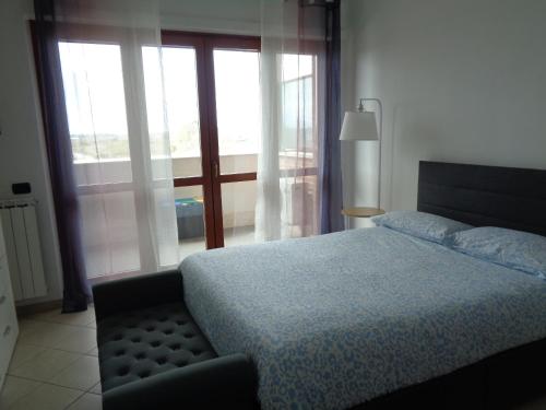 a bedroom with a bed and a large window at Locazione Turistica Gloria in Fiumicino Airport